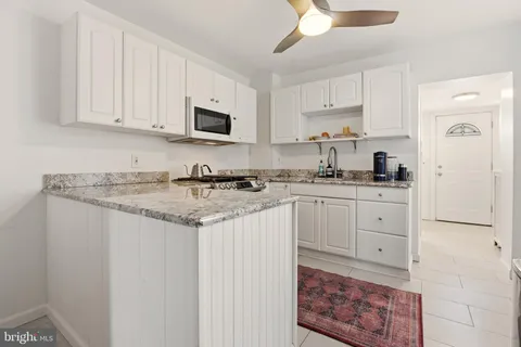 a kitchen with granite countertop white cabinets and stainless steel appliances