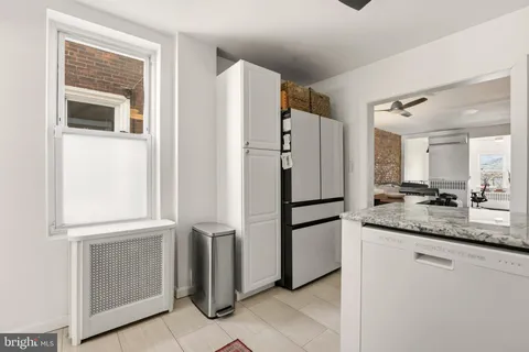 a kitchen with granite countertop a refrigerator and a sink