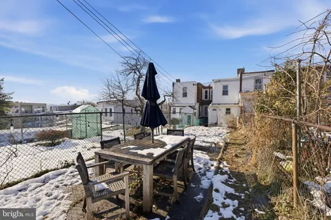 a view of a patio with table and chairs with wooden fence