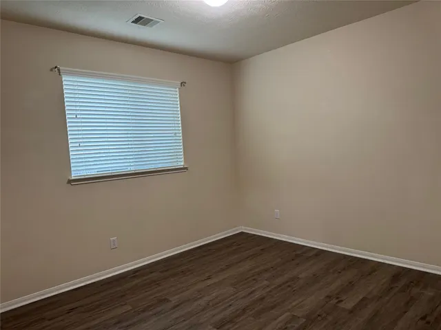 a view of a small space with wooden floor and a window