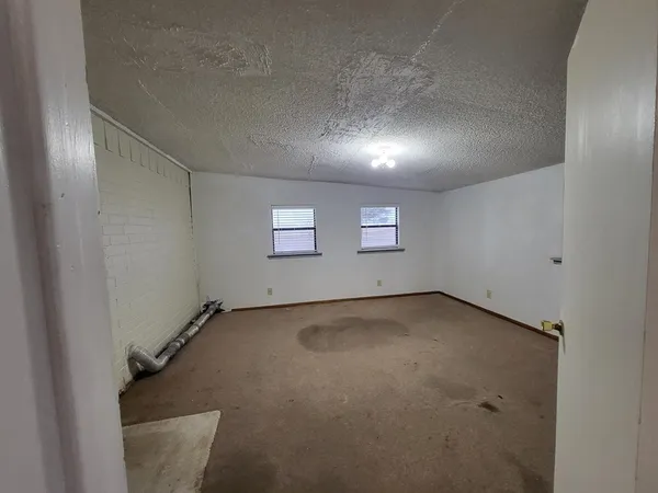 an empty room with a empty space and windows
