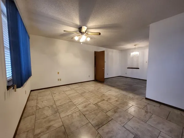 a view of a livingroom with a ceiling fan and window