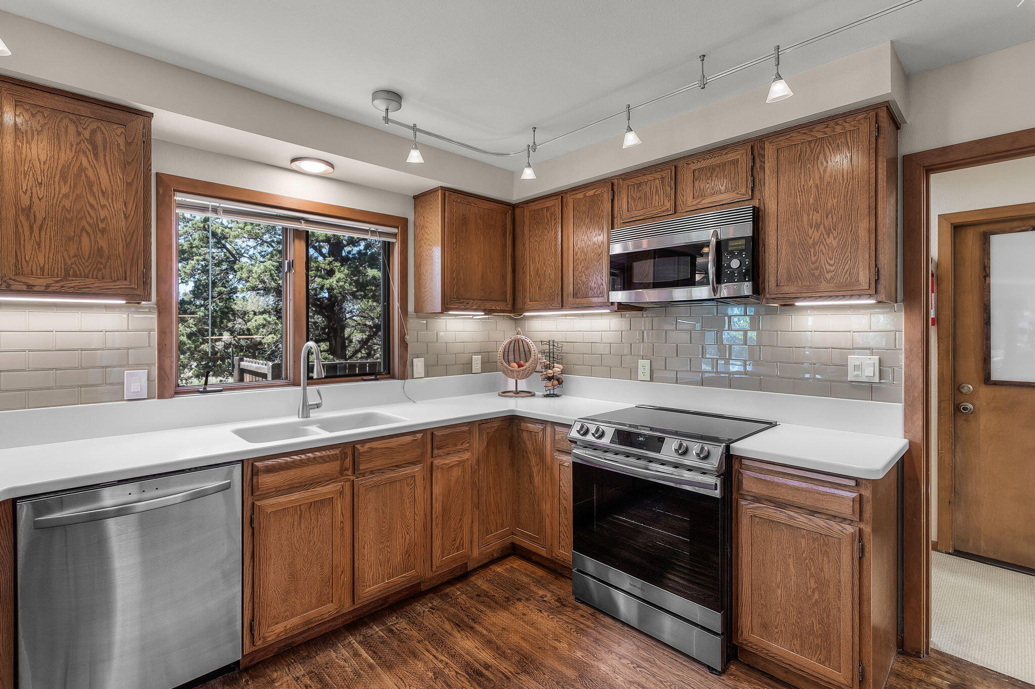 64620 McGrath Road Bend, OR 97701 - Photo 14 of 28 a kitchen with stainless steel appliances granite countertop a sink a stove a microwave and wooden cabinets