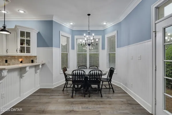 a view of a a dining room with furniture window and wooden floor