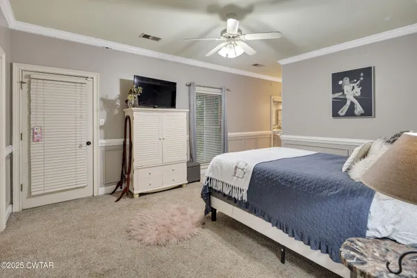 a spacious bedroom with a bed and a flat screen tv