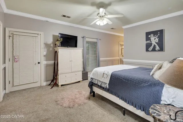 a spacious bedroom with a bed and a flat screen tv