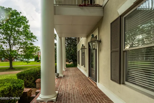 a view of a porch with wooden floor and a yard