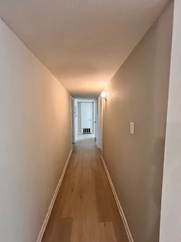 a view of hallway with wooden floor