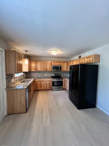 a large kitchen with a large counter top and stainless steel appliances