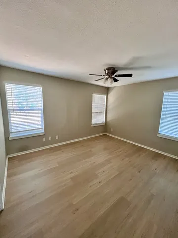 an empty room with windows and closet