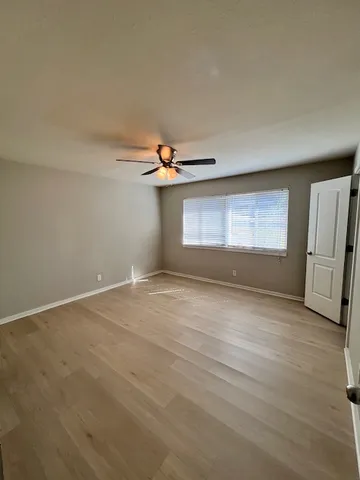 an empty room with windows and cabinet