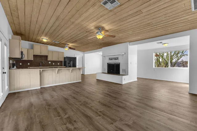 a view of an empty room with a fireplace and a window