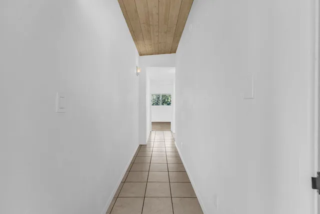 a spacious bedroom with a large bed couch and a potted plant