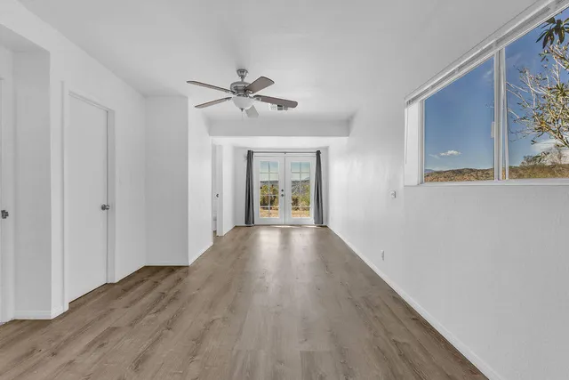 a view of empty room with wooden floor