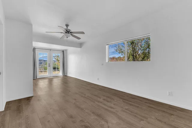 a view of a hallway with wooden floor and a bathroom