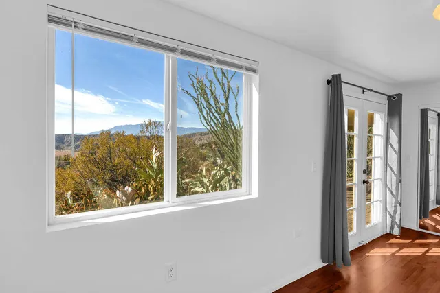 a view of a dry yard with mountains and green space