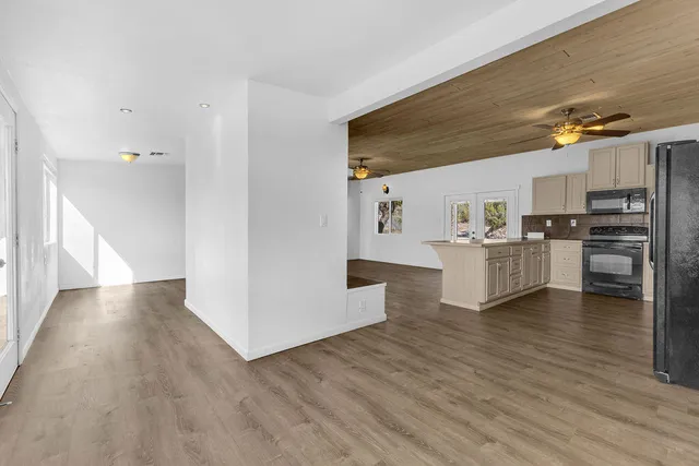 a view of a kitchen with a sink and dishwasher a refrigerator with wooden floor