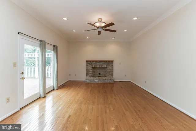 a view of an empty room with a window and a fireplace