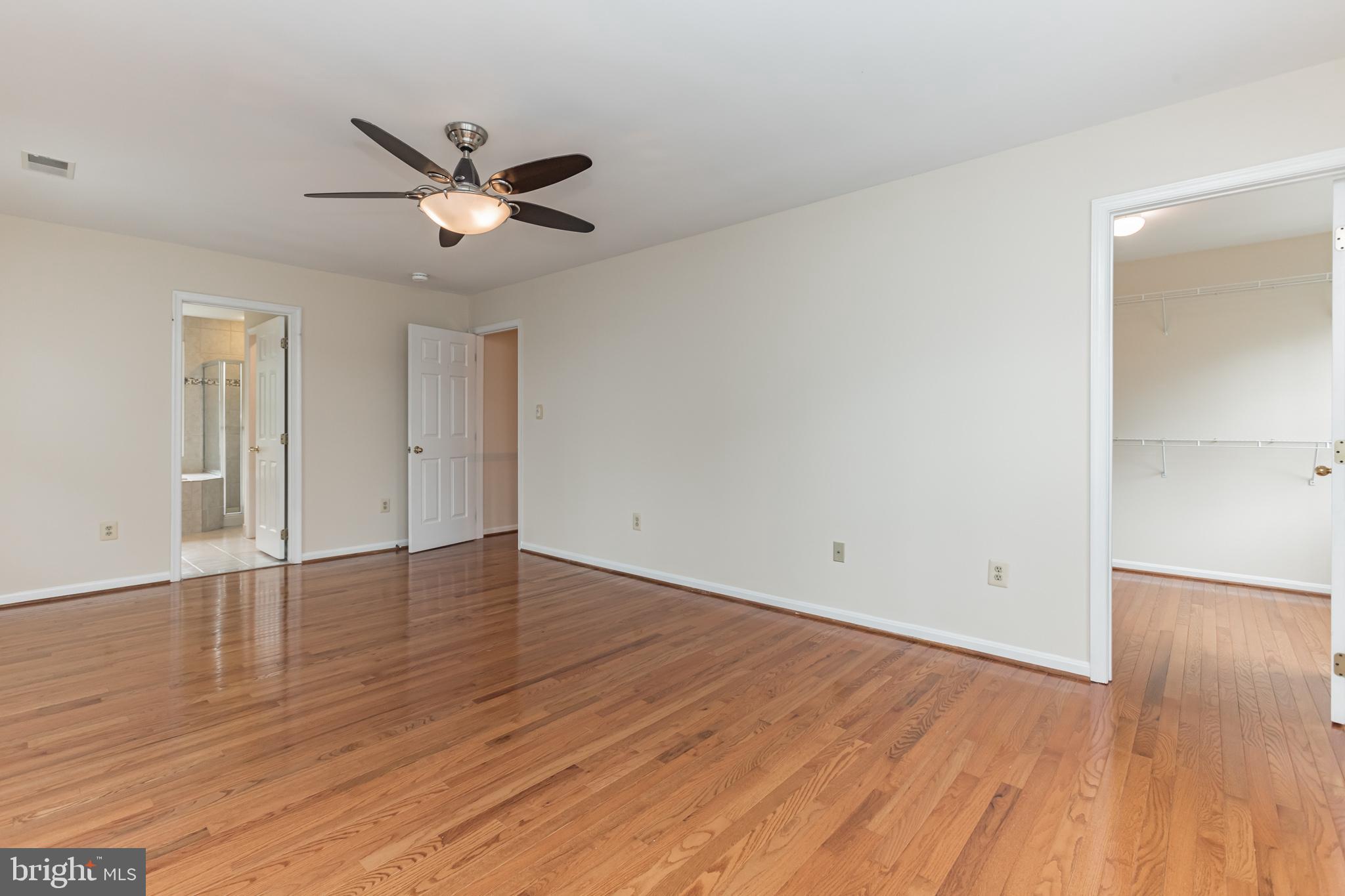 13907 Willow Tree Drive Rockville, MD 20850 - Photo 17 of 30 an empty room with wooden floor a ceiling fan and closet