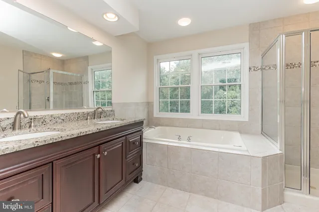 a spacious bathroom with a granite countertop tub sink and mirror