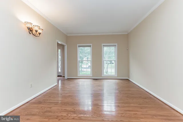 an empty room with wooden floor and window