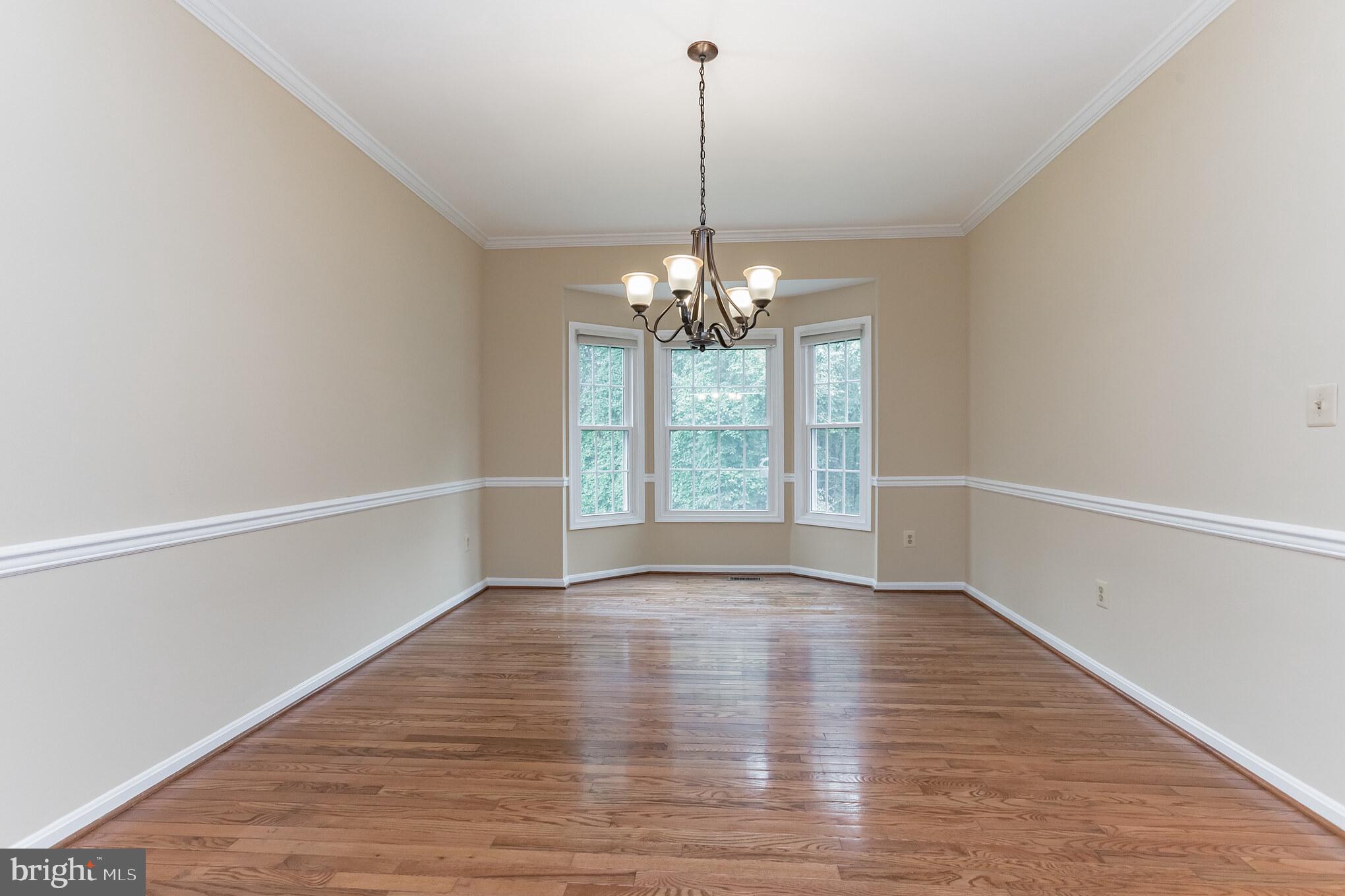 13907 Willow Tree Drive Rockville, MD 20850 - Photo 5 of 30 a view of an empty room with wooden floor and a window