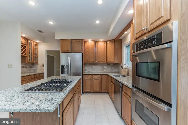 a kitchen with stainless steel appliances granite countertop sink stove and refrigerator