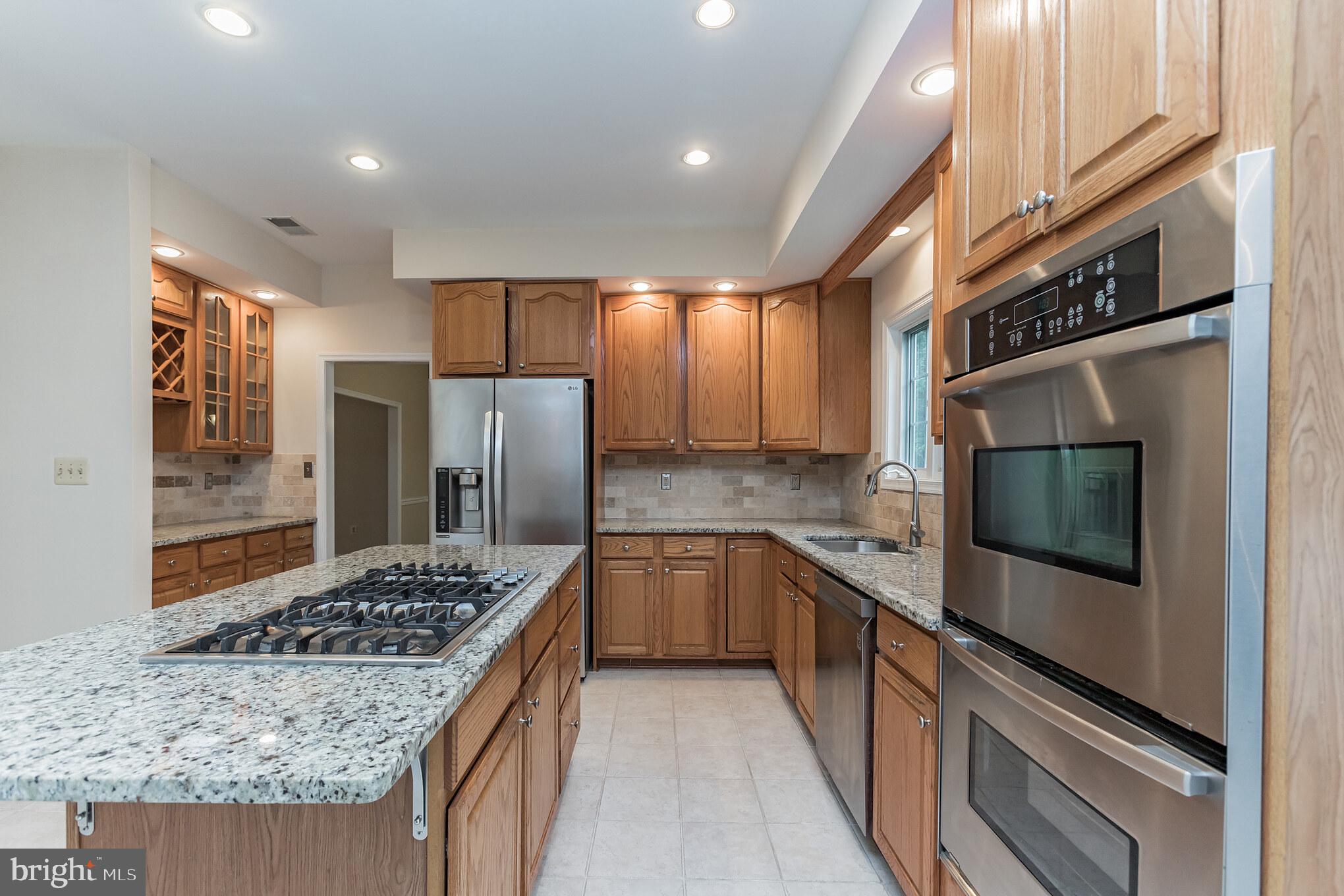 13907 Willow Tree Drive Rockville, MD 20850 - Photo 6 of 30 a kitchen with stainless steel appliances granite countertop sink stove and refrigerator