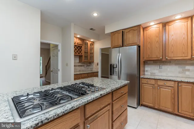 a kitchen with kitchen island granite countertop a stove and a refrigerator