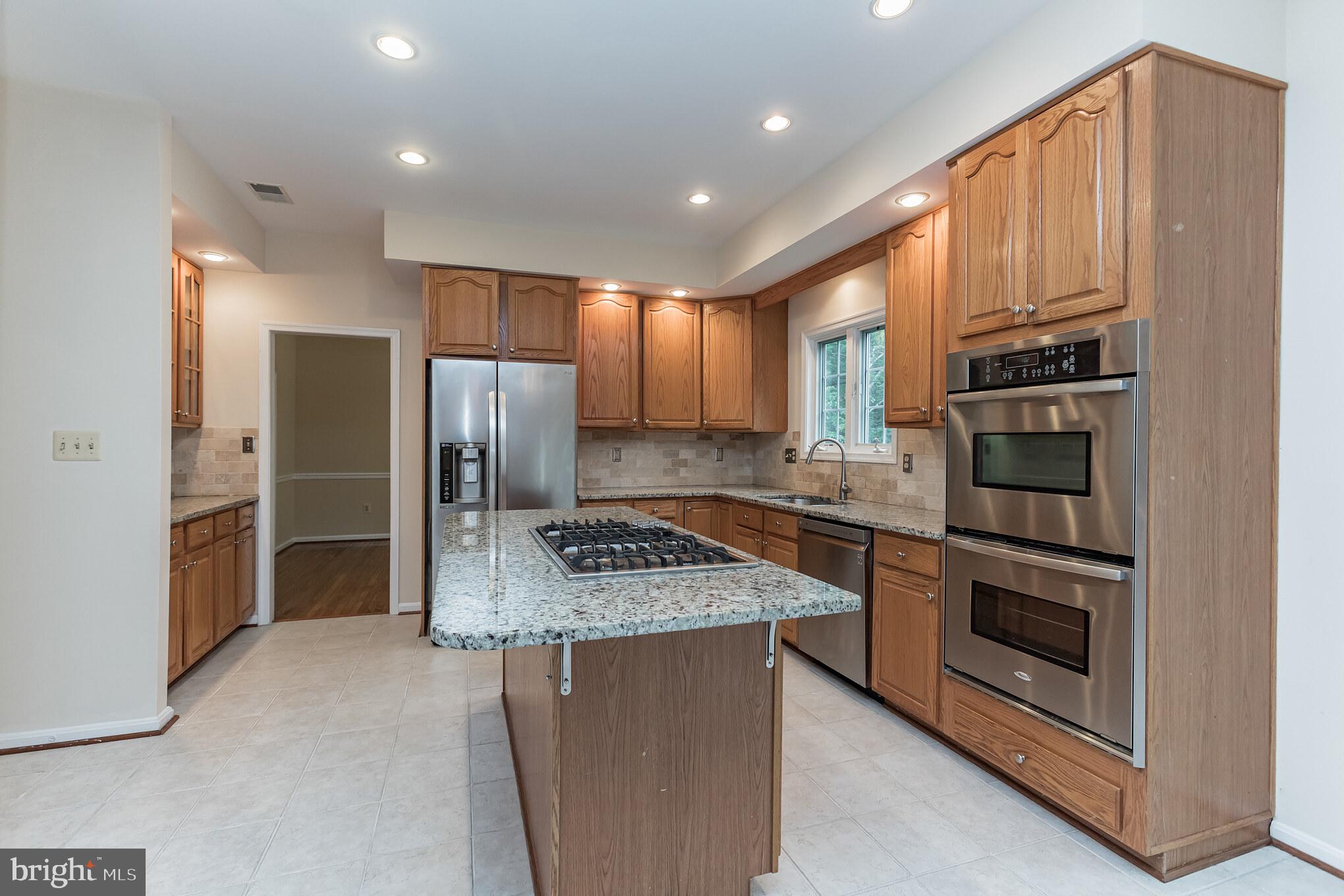 13907 Willow Tree Drive Rockville, MD 20850 - Photo 9 of 30 a kitchen with stainless steel appliances granite countertop a refrigerator stove and oven