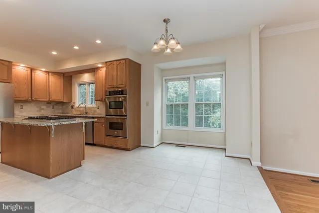 a large kitchen with stainless steel appliances granite countertop a stove and a sink with cabinets