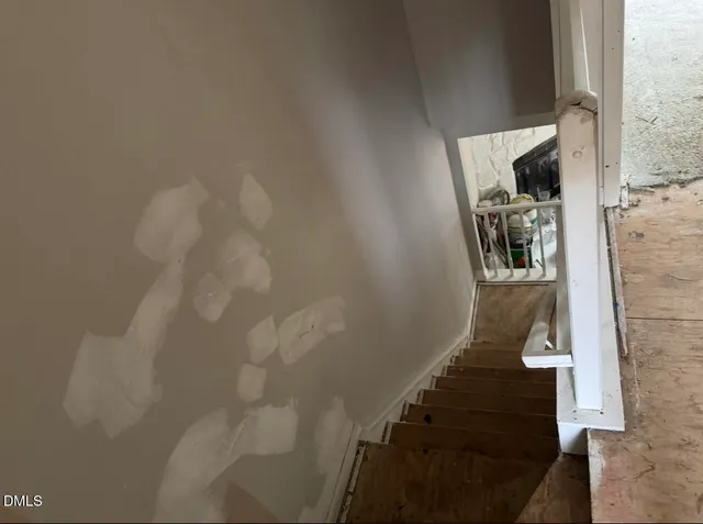 a view of staircase with lots of frames on wall and windows