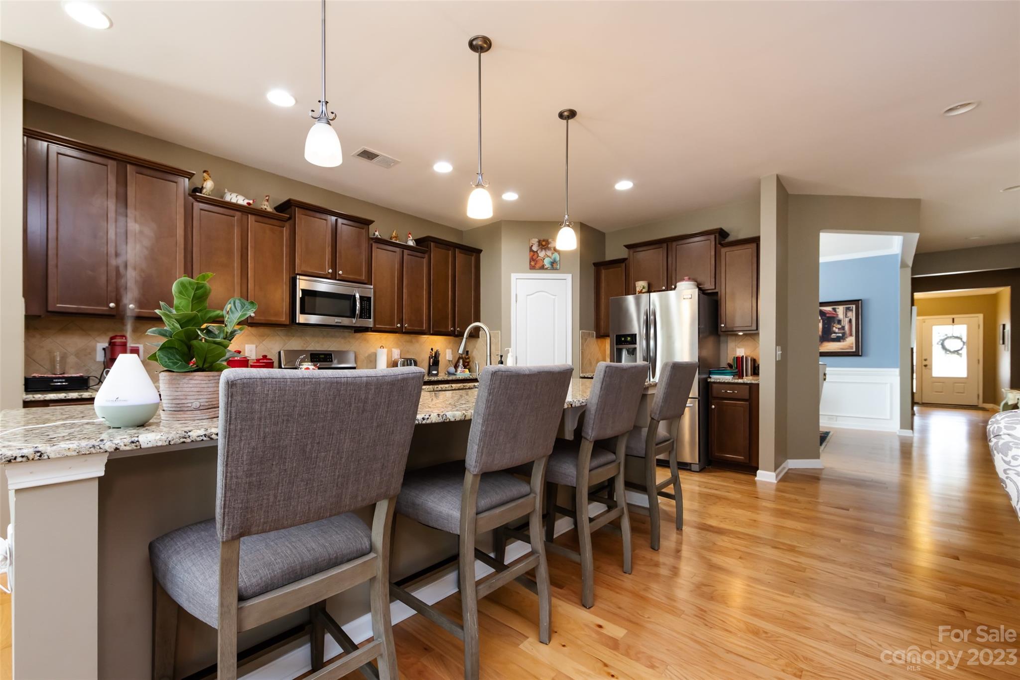 4316 Perth Road Indian Land, SC 29707 - Photo 13 of 48 a kitchen with stainless steel appliances kitchen island granite countertop a dining table chairs refrigerator and microwave
