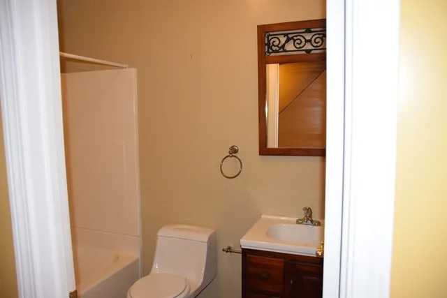 a bathroom with a sink toilet and mirror