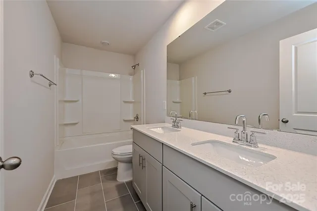 a bathroom with a granite countertop sink a toilet and shower