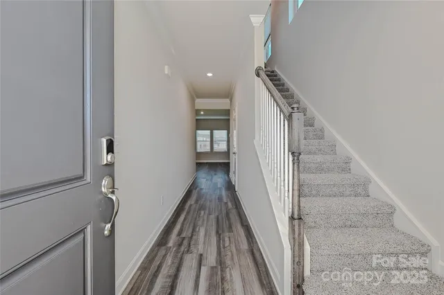 a view of a hallway with wooden floor and staircase