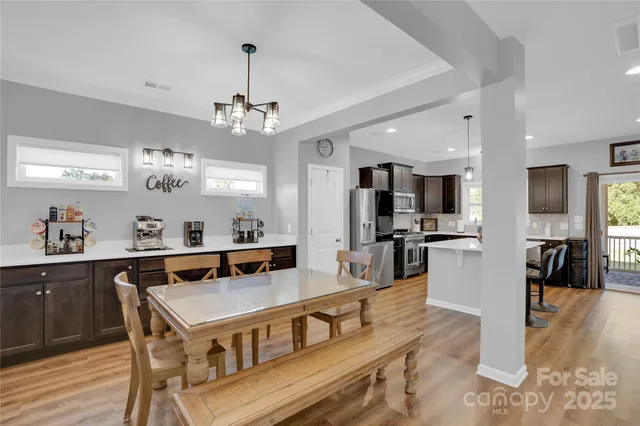 a view of a dining room with furniture a chandelier and wooden floor
