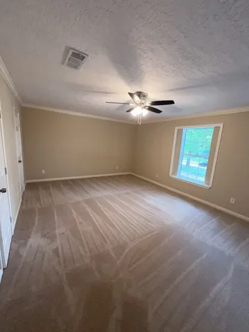 en empty room with windows and chandelier fan
