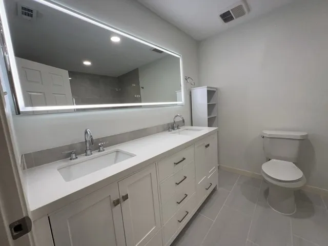 a bathroom with a double vanity sink and a toilet