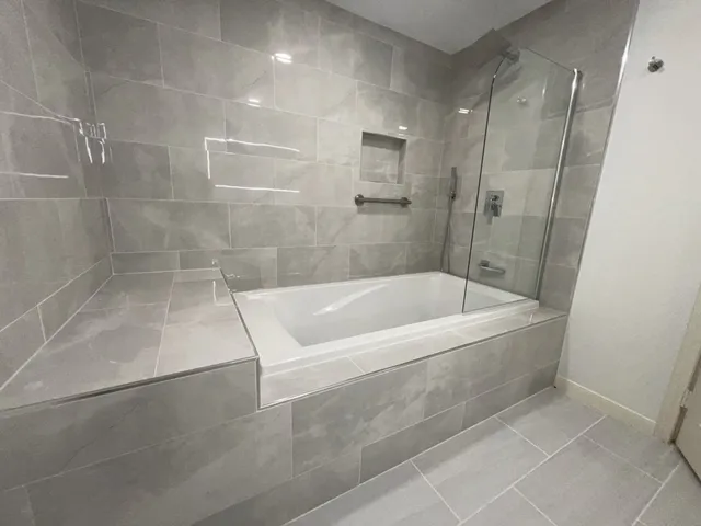 a white bath tub sitting next to a shower