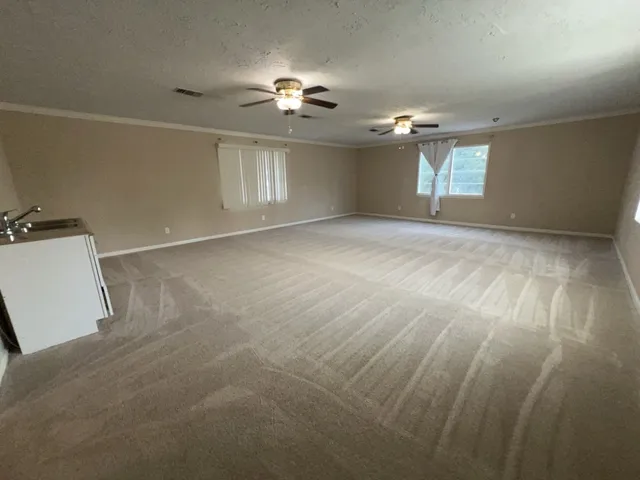 a view of a livingroom with a ceiling fan and window