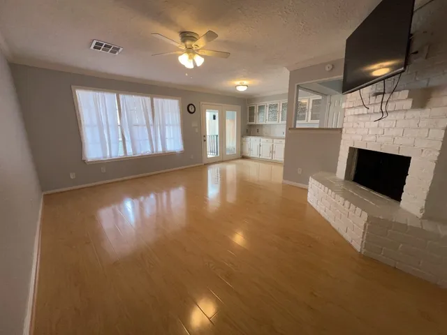 a view of an empty room with a fireplace and a window