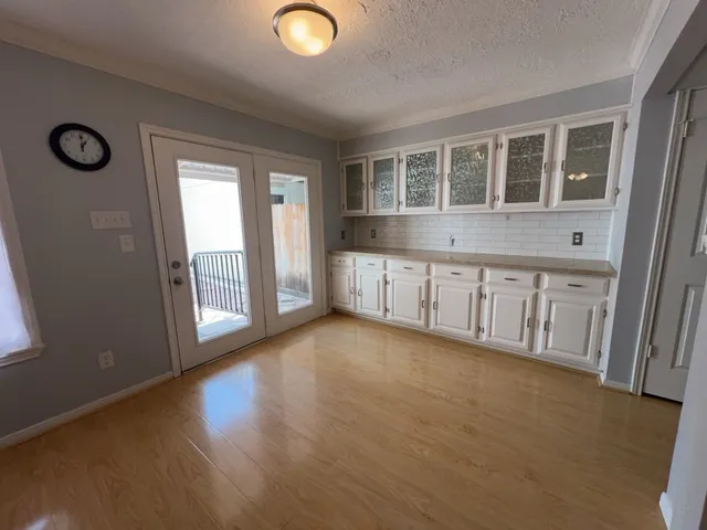 a view of an empty room with wooden floor and windows