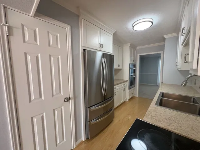 a kitchen with granite countertop a refrigerator and a sink