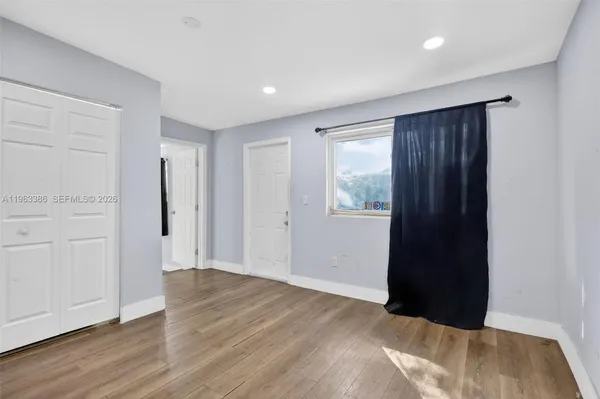 a view of an empty room with wooden floor