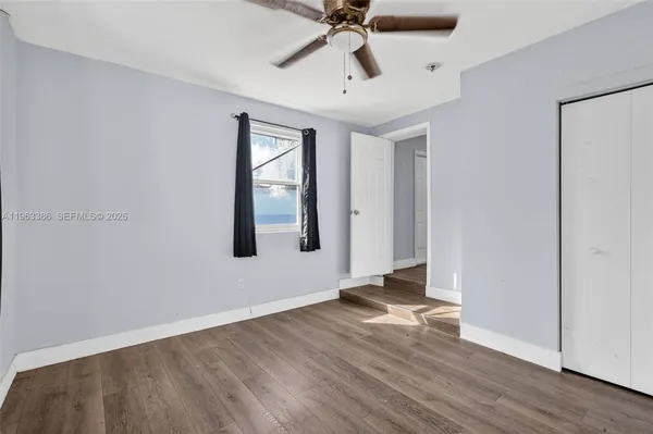 a view of an empty room with wooden floor