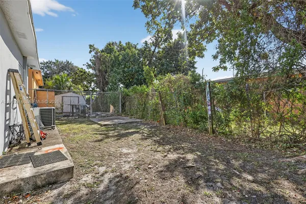 a view of a backyard with plants and trees