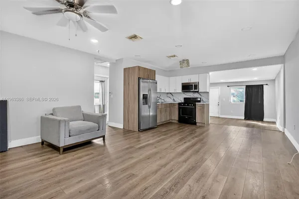 a living room with furniture and kitchen view