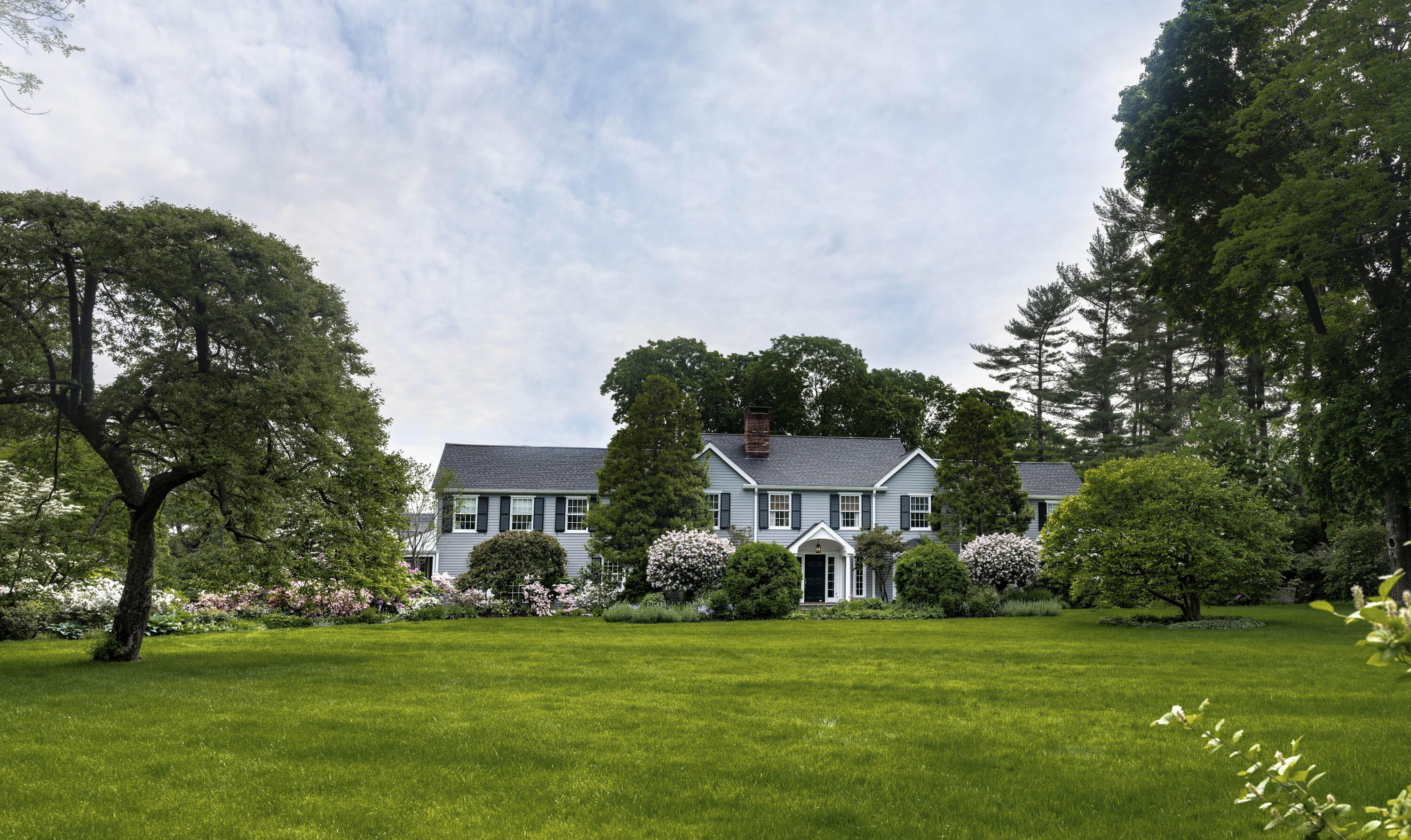 35 Rosebrook Road New Canaan, CT 06840 - Photo 3 of 38 a front view of a house with a yard and trees