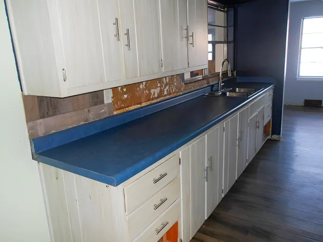 an empty room with windows and fireplace